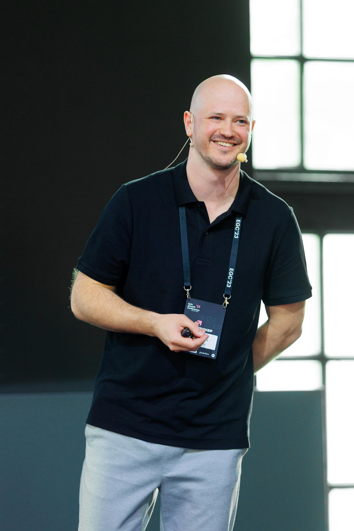 Alex — founder of AppCraft, on stage with a headset microphone.